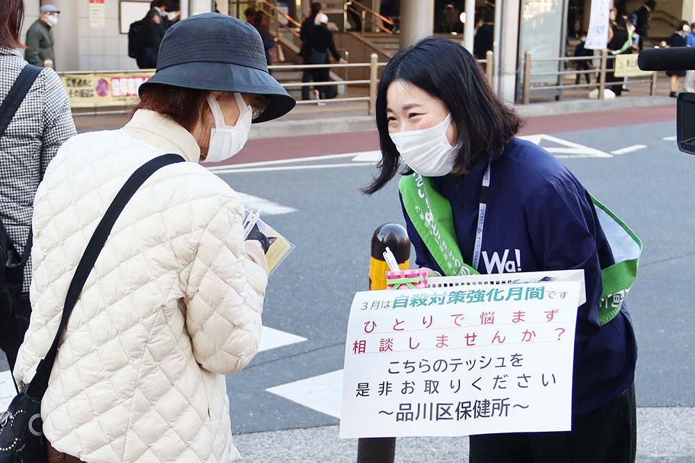 大井町駅前で啓発物を配布し周知する様子